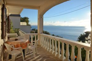 a balcony with a table and chairs and a view of the ocean at Apartments Marijana in Zavalatica