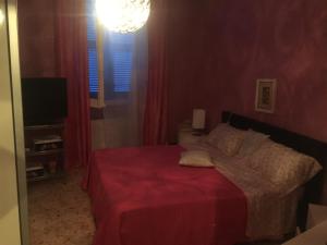 a bedroom with a bed with a red bedspread at Appartamento Porzione di villa "il cappello d'oro" in Chiavari