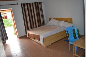 a bedroom with a bed and a table and a blue chair at Wailers Lodge in Kigali