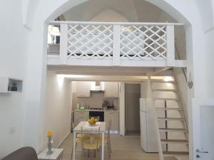 a loft bed in a small room with a kitchen at Il Nido della Calandra in Tuglie