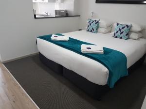 a bedroom with a large bed with towels on it at Hamilton on Beaumont in Newcastle