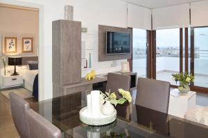 a living room with a dining table and a tv at Terrazas de Campoamor by Mar Holidays in Playas de Orihuela