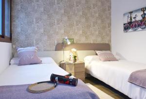 プレヤス・デ・オリフエラにあるTerrazas de Campoamor by Mar Holidaysのベッド2台、テニスラケット付きのベッドが備わるホテルルームです。