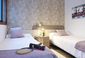a hotel room with two beds with a tennis racket on the bed at Terrazas de Campoamor by Mar Holidays in Playas de Orihuela +35 photos