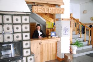 a woman standing at a counter in a restaurant at Maison Blanche Ecohousе in Mytnitsa