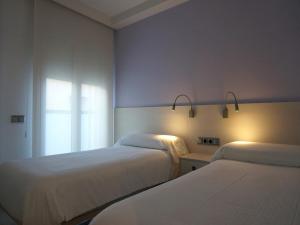 1 dormitorio con 2 camas y ventana en Llevant I Ponent, en Palamós