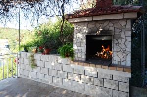 a brick fireplace with a fire place on a patio at Apartments Marijana in Zavalatica