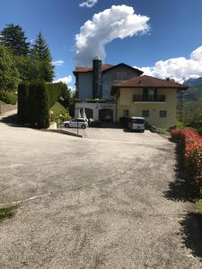 a house with a car parked in a driveway at Hotel Scaranò in Levico Terme