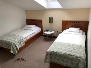 a hotel room with two beds and a table at Hotel Hvala Superior - Topli Val in Kobarid