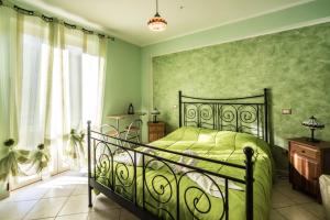 una camera verde con un letto e una finestra di Locanda Belvedere Da Stefano a Rocchetta a Volturno