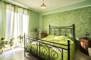 - une chambre verte avec un lit et une fenêtre dans l'établissement Locanda Belvedere Da Stefano, à Rocchetta a Volturno