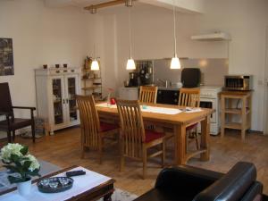 eine Küche und ein Wohnzimmer mit einem Holztisch und Stühlen in der Unterkunft Ferienwohnungen Marktstrasse 15 in Quedlinburg