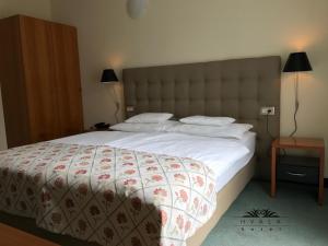 a bedroom with a large white bed with a large headboard at Hotel Hvala Superior - Topli Val in Kobarid