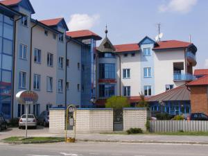 una fila de edificios con coches estacionados en un estacionamiento en Hotel Vion, en Zlaté Moravce