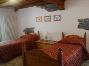 1 dormitorio con 2 camas y edredón rojo en Auberge Lou Créton di Lui Hostel, en Pontboset