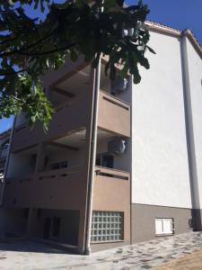 a building with an open door on the side of it at Apartments Orhideja in Rab