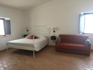 a bedroom with a bed and a couch at Appartamenti Il Criollo in San Gimignano