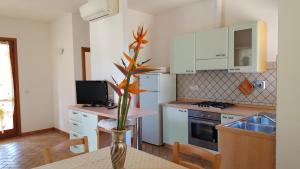 a kitchen with a table with a vase with a plant in it at Agriturismo Rebua in Porto Azzurro