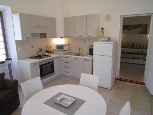 una cocina con electrodomésticos blancos, mesa y sillas en Majella Garden, Rapino, en Rapino