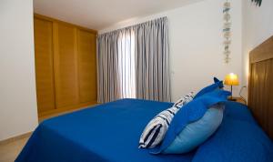 a bedroom with a blue bed with an inf pillow at Casa Paradise in Cotillo