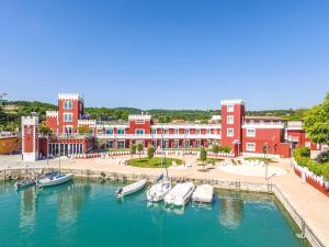 eine Gruppe von Booten, die in einem Hafen mit Gebäuden angedockt sind in der Unterkunft Hotel Villa Garuti in Padenghe sul Garda