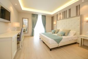 ein Hotelzimmer mit einem Bett, einem Schreibtisch und einem Fenster in der Unterkunft Hotel Villa Garuti in Padenghe sul Garda
