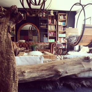 a living room with a log couch and a mirror at Un Autre Monde in Saint-Claude