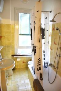 a bathroom with a shower curtain with a sink and a toilet at A casa del cuoco in Florence
