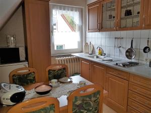 a kitchen with a table and chairs and a sink at Ferienwohnung Zum Wald in Ostseebad Sellin
