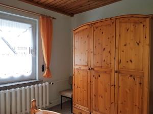 a bedroom with a wooden cabinet and a window at Ferienwohnung Zum Wald in Ostseebad Sellin