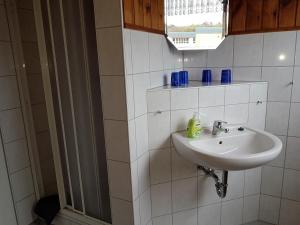 a white bathroom with a sink and a window at Ferienwohnung Zum Wald in Ostseebad Sellin +13 photos