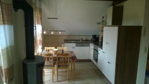 a kitchen with a table and a kitchen with a stove at Ferienhaus Leo und Livia in Zempin +19 photos