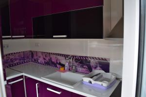a kitchen with purple cabinets and a sink at Kalina Family Hotel in Burgas +49 photos