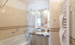 a bathroom with a tub and a sink and a shower at La Closerie SPA & Résidence Hôtel in Deauville