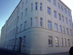 a large white building on the side of a street at Design apartment in Liepāja