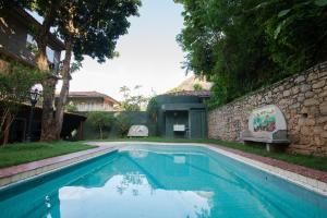 a swimming pool in a yard with a stone wall at Rio Boutique Suites in Rio de Janeiro