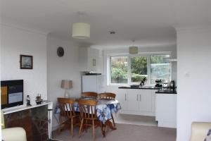 a kitchen and dining room with a table and chairs at Sea Crest in Brixham
