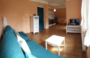 een woonkamer met een blauwe bank en een tv bij Apartment Jakubske Namesti in Česká Kamenice