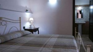 1 dormitorio con 1 cama, lavamanos y lámpara en Agriturismo San Marco en Dragoni