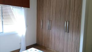 un armario de madera en una habitación con ventana en Modern City Center Apt, en Lárnaca