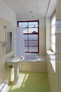 a bathroom with a sink and a window and a tub at Pärnu Jahtklubi Külalistemaja in Pärnu +21 photos