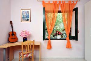 TorcaにあるCasa Honeyの窓(オレンジ色のカーテン、木製デスク付)