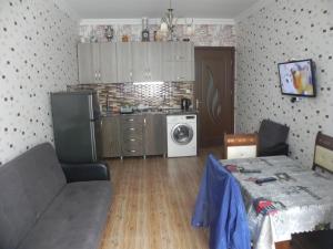 a living room with a table and a kitchen at Apartment Rustaveli 59 in Batumi