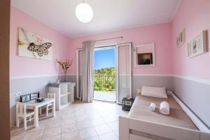 a bedroom with pink walls and a bed and a balcony at Harmony Marathias luxury apartment in Marathias