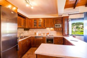 a kitchen with wooden cabinets and a stainless steel refrigerator at Harmony Marathias luxury apartment in Marathias