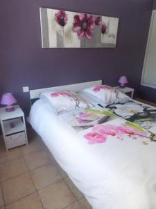 ユゼスにあるAppart'17-Domaine de la sourceのベッドルーム1室(ピンクの花が咲く白いベッド1台付)