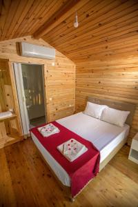 a bedroom with a bed in a wooden room at Likya Evleri Olympos in Olympos +20 photos