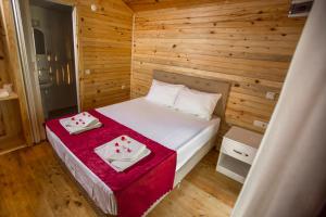 a small room with a bed in a wooden wall at Likya Evleri Olympos in Olympos