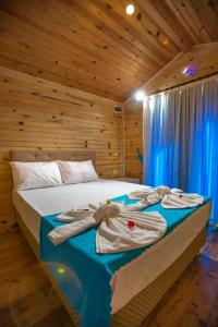 a bedroom with a bed with towels on it at Likya Evleri Olympos in Olympos