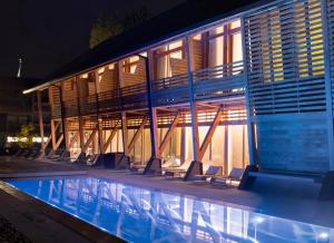 ein Schwimmbad vor einem Gebäude bei Nacht in der Unterkunft Hotel des Berges, Restaurant Gastronomique & Spa in Illhaeusern